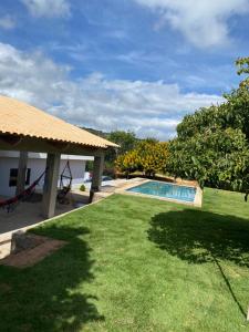 a backyard with a swimming pool and a grass yard at Chacara Pe. Cicero in Triunfo