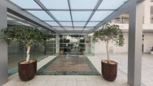 ein Flur mit zwei Topfbäumen in einem Gebäude in der Unterkunft PLATAN Apartment in Salou