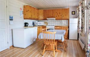 uma cozinha com armários de madeira e uma mesa e cadeiras em Cozy Home In Lyngdal With Kitchen em Lyngdal