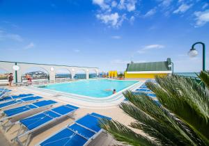 una piscina en un crucero con tumbonas azules en Cristoforo Colombo, en Caorle