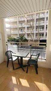ein Tisch und zwei Stühle auf einem Balkon mit Fenster in der Unterkunft PLATAN Apartment in Salou