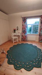 een woonkamer met een groen tapijt op een houten vloer bij Mökki Kainula in Veteli