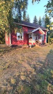 uma pequena casa vermelha no meio de um campo em Mökki Kainula em Veteli