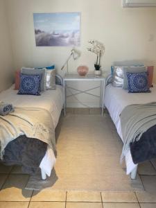 um quarto com duas camas e uma mesa com um candeeiro em Cosy Haven For Females Only or Females & Child/ren em Brisbane