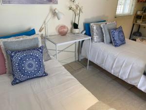 uma sala de estar com duas camas e uma mesa em Cosy Haven For Females Only or Females & Child/ren em Brisbane