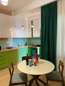 uma cozinha com uma mesa e uma garrafa de vinho em Lovely and cozy apartment! em Kutaisi