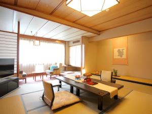 a large living room with a table and chairs at Hanamomiji in Jozankei