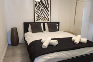 a bedroom with a large bed with three pillows at דירת גג WOW מול רוטשילד תל אביב in Tel Aviv