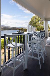 a porch with a table and chairs and a view of the water at Woodland Bay Retreat-Hot tub,Sauna and Bayview Retreat in Lymington