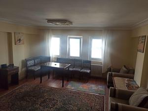 uma sala de estar com uma mesa, cadeiras e janelas em This house is Not active em Altındağ