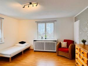 sala de estar con radiador y silla roja en Apartment Alexandra - Handwerker willkommen, Parkplatz, Küche, WLAN, en Malterdingen