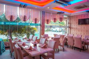 a restaurant with tables and chairs in a room at Greenlight Hotel in Dar es Salaam