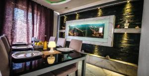 una sala da pranzo con tavolo e un dipinto sul muro di Sunshell luxury apartment a Lija