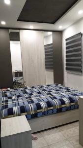 - une chambre dotée d'un lit avec une couverture bleue et blanche dans l'établissement Sunshell, à Lija