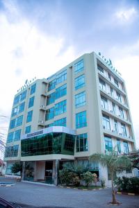 Un grand bâtiment blanc avec des fenêtres donne sur une rue. dans l'établissement Greenlight Hotel, à Dar es Salaam