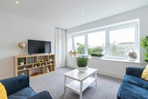 a living room with a blue couch and a window at Spacious 3 Bed Home in Cheltenham
