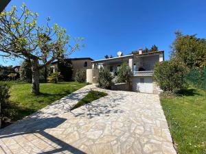 uma casa com uma entrada de pedra em frente a uma casa em Villa Karigador, Umag- Karigador, Istria em Karigador