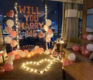ein Wohnzimmer mit Ballons und ein Schild, das liest Willst du mich heiraten? in der Unterkunft Family Seaview Suite with 3 Rooms by The Only Bnb in Tanjong Tokong