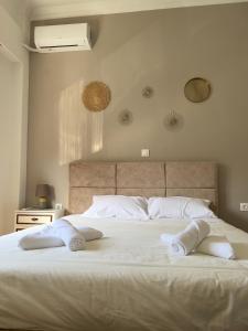 una camera da letto con un letto bianco con due asciugamani di Seaside Casa a Nafpaktos