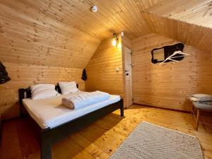 a bedroom with a bed in a wooden room at Chalet Nomad in Petroşani