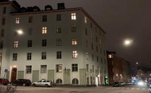 een groot wit gebouw 's nachts met auto's geparkeerd buiten bij Rustic black and white studio in Helsinki