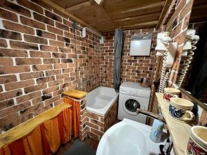 a brick bathroom with a washing machine and a sink at Chalet Nomad in Petroşani +21 photos