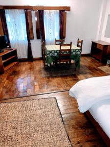 a bedroom with a table and chairs and a bed at KEN & TWILL in Shillong
