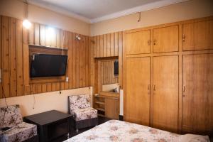 a bedroom with a bed and a tv and a chair at SETHI's HOMESTAY in Srinagar