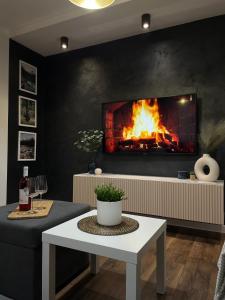 a living room with a fireplace and a table at No 59 Apartament in Nowy Targ