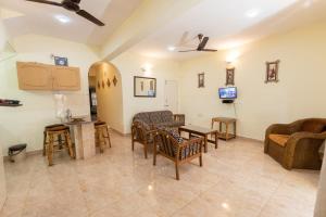 sala de estar con sillas y mesa en Beach Village Holiday Homes Goa en Colva