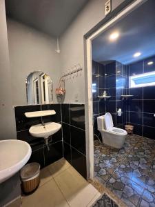 een badkamer met een wastafel, een toilet en een spiegel bij Valentine Boutique hotel - 29 Bui Vien street in Ho Chi Minh-stad