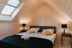 ein Schlafzimmer mit einem großen Bett im Dachgeschoss in der Unterkunft Kaszubski Raj in Chmielno