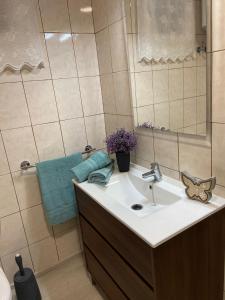 uma casa de banho com um lavatório e um espelho em Moderno apartamento al lado del mar em Tacoronte