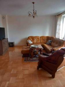 un soggiorno con divano in pelle e tavolo di Apartament 65 m2 w centrum Łowicza a Łowicz