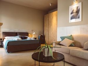 ein Schlafzimmer mit einem Bett, einem Sofa und einem Tisch in der Unterkunft B&B Casa di Gio' in Tiggiano
