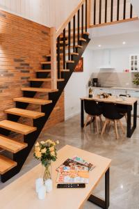 eine Treppe in einem Wohnzimmer mit einem Tisch und einer Küche in der Unterkunft Kaszubski Raj in Chmielno