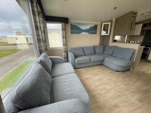 a living room with a couch and a large window at Marine Holiday Park in Rhyl