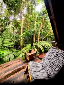 una terraza de madera con un banco y una mesa en Casa Embira - 300 metros da Praia do Lago Verde, en Alter do Chao