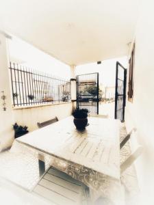 泰爾莫利的住宿－Simpatico appartamento autonomo sul mare，阳台上的白色桌子上放着盆栽植物