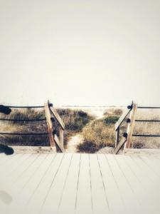 two wooden benches on a boardwalk near the beach at Simpatico appartamento autonomo sul mare in Termoli