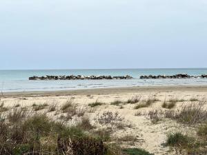 uma praia arenosa com um grupo de rochas no oceano em Simpatico appartamento autonomo sul mare em Termoli