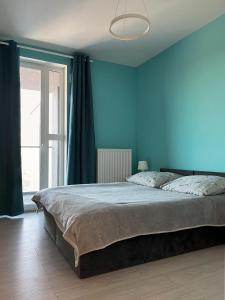1 dormitorio con 1 cama grande y paredes azules en Apartament z widokiem na panoramę Gdyni w Modern Tower ATAL, en Gdynia