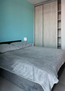 1 dormitorio con 1 cama grande y pared de madera en Apartament z widokiem na panoramę Gdyni w Modern Tower ATAL, en Gdynia