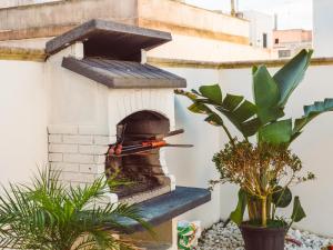 un horno de pizza al aire libre en un jardín con plantas en B&B Casa di Gio', en Tiggiano