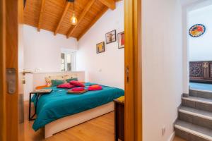 a bedroom with a bed with blue sheets and red pillows at Downtown Lady Terrace in Faro
