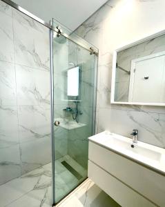 a bathroom with a glass shower and a sink at By the Beach Villa Natalya in Protaras