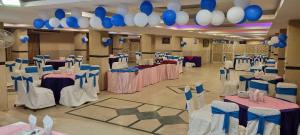 a banquet hall with tables and blue and white balloons at Grace Crown Hotel in Rawalpindi