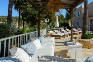 eine Gruppe weißer Liegestühle auf einer Terrasse in der Unterkunft Villa Cas Puig - Beach of Portinatx in Portinatx