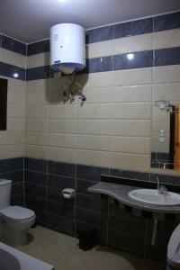 a bathroom with a toilet and a sink and a mirror at Apartment im Al-Manar House Safaga in Hurghada