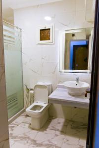 Regency Hotel Alexandria في الإسكندرية: حمام مع مرحاض ومغسلة ودش